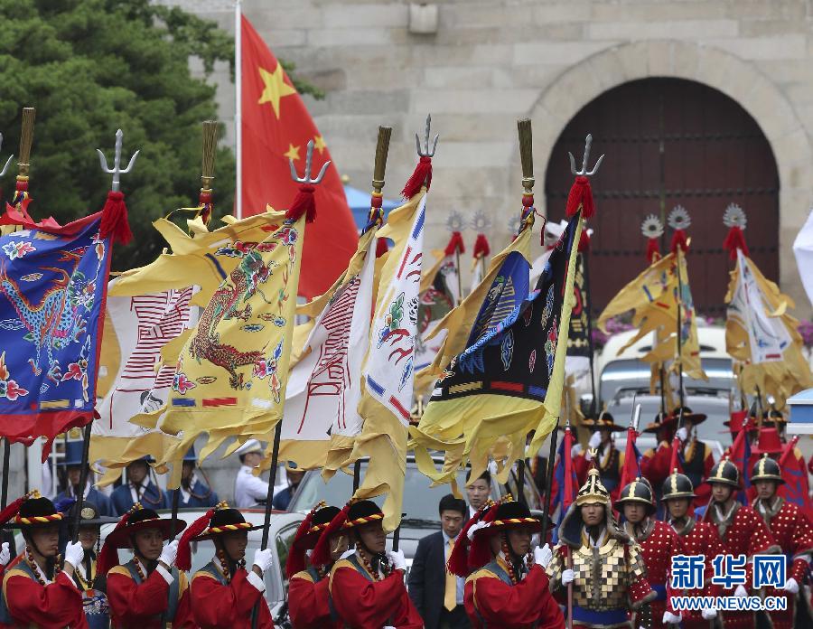 7月3日，韩国总统朴槿惠在青瓦台总统府举行隆重仪式，欢迎中国国家主席习近平对韩国进行国事访问。这是习近平的车队在身着民族服装的韩国礼仪队伍引导下驶入青瓦台。新华社记者丁林摄  